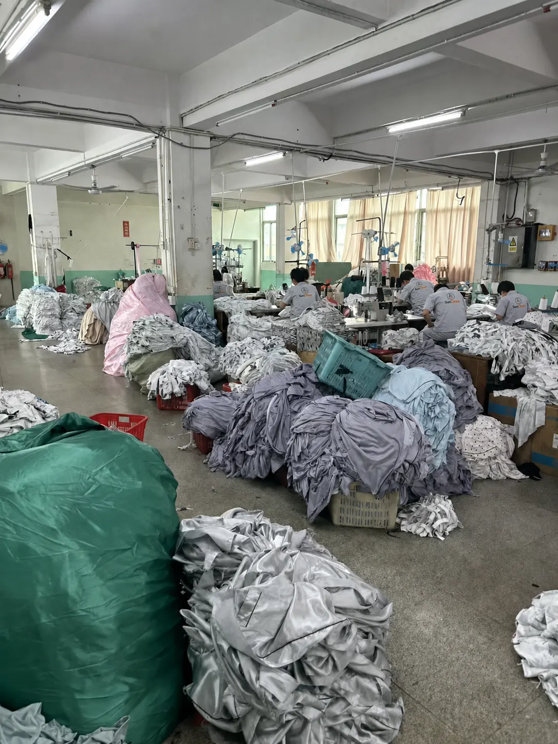 SunCheer workers sewing padded jacket components on the production floor